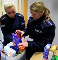 policjanci pakują zebrane produkty do szlachetnych paczek