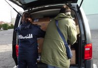 policjantka i wolontariusz pakują paczki do samochodu