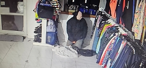Zdjęcie przestawia zamaskowanego mężczyznę, który włamał się do sklepu sportowego.