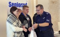 Komendant Powiatowy Policji w Prudniku wręcza drobne upominki uczniom klasy mundurowej.