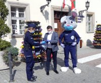 Burmistrz Głogówka Piotr Bujak przekazuje policjantom maseczki ochronne dla mieszkańców gminy.