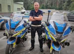 na zdjęciu funkcjonariusz ruchu drogowego stoi przy policyjnych motocyklach