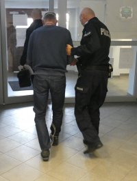 Policjanci doprowadzają osobę zatrzymaną na posiedzenie sądu