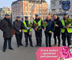Zdjęcie przedstawia policjantów stojących z kwiatami.