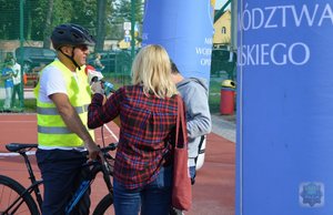 Marszałek Województwa Opolskiego stoi przy swoim rowerze i udziela informacji mediom