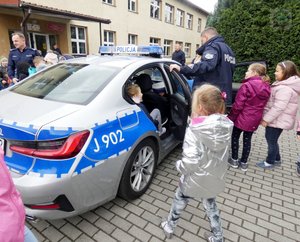 dzieci wchodzą do radiowozu policyjnego
